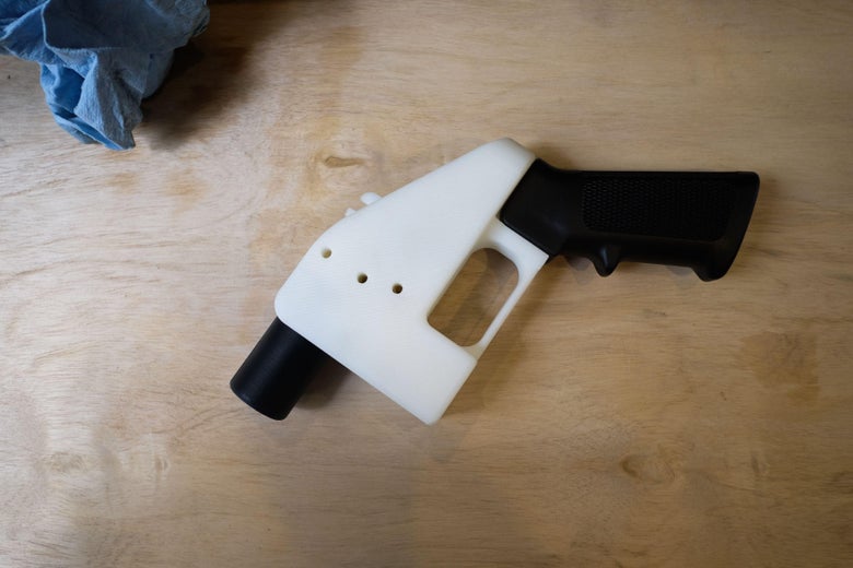 A black-and-white plastic gun rests on wood.